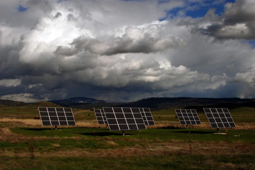 Solar panels tolerate wind speeds in open country with clouds and cows